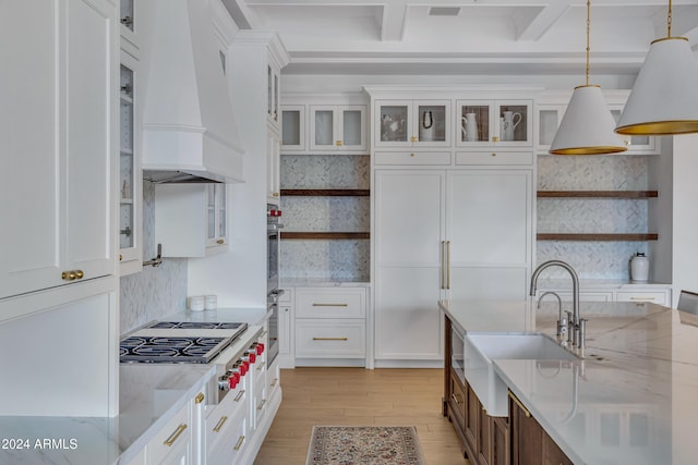 kitchen featuring premium range hood, hanging light fixtures, light hardwood / wood-style flooring, and white cabinetry