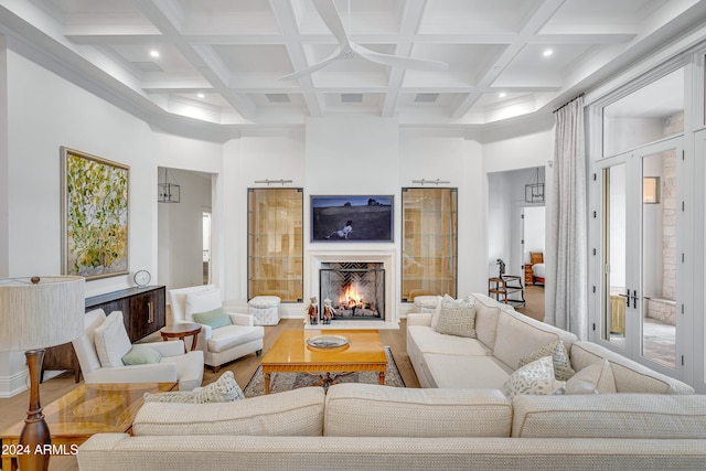 living room featuring a wealth of natural light, beamed ceiling, hardwood / wood-style flooring, and ceiling fan