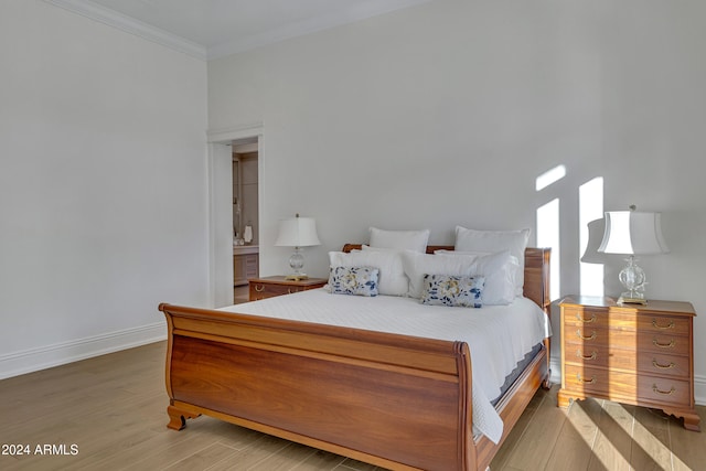 bedroom with crown molding and wood-type flooring