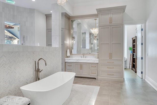 bathroom featuring tile walls, a bathing tub, vanity, crown molding, and tile patterned flooring