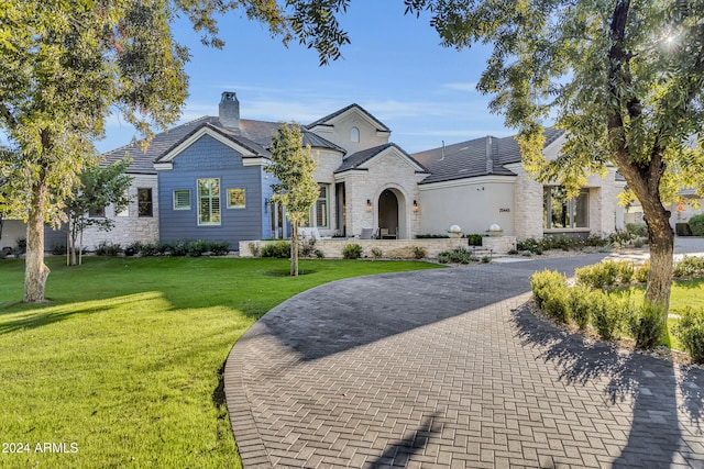 french provincial home with a front yard