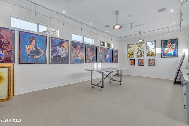 recreation room featuring concrete floors, ceiling fan, and a wealth of natural light