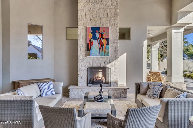 living room with an outdoor stone fireplace and plenty of natural light