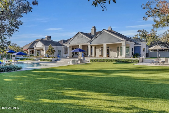 back of house with a patio area and a lawn