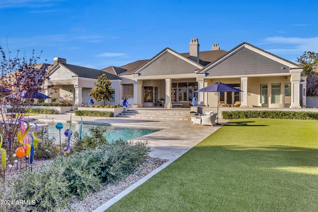 rear view of house featuring a patio and a yard