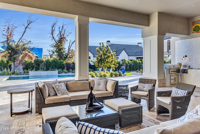 view of patio / terrace featuring exterior kitchen, area for grilling, outdoor lounge area, and pool water feature