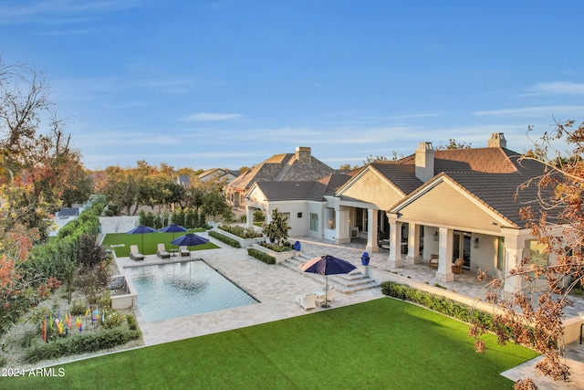 view of swimming pool featuring a patio and a yard