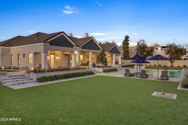 rear view of property featuring a yard and a patio