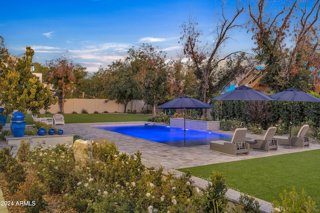 view of pool featuring a patio, pool water feature, and a lawn