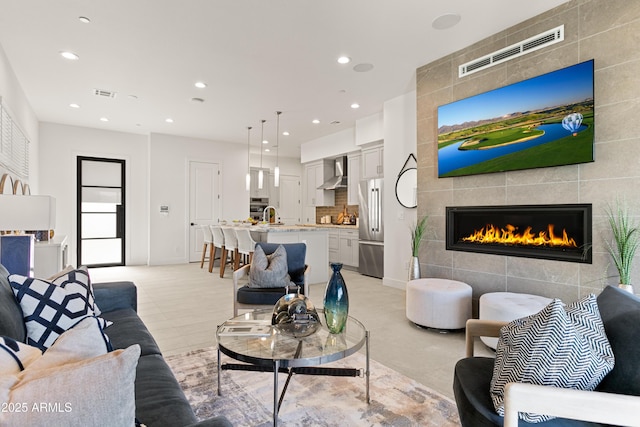 tiled living room featuring a tile fireplace and sink