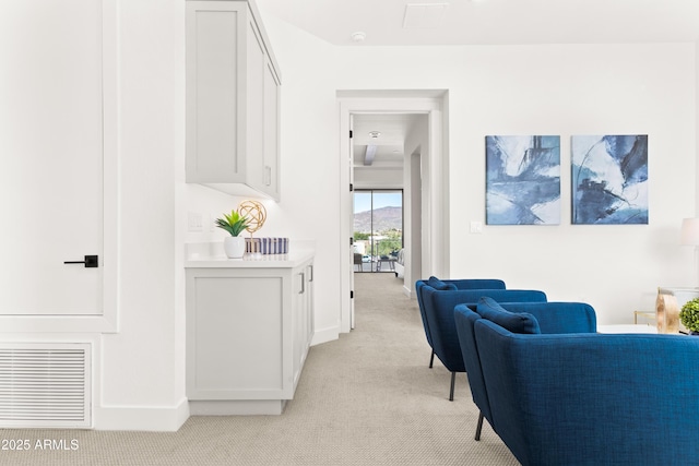 hallway featuring light colored carpet