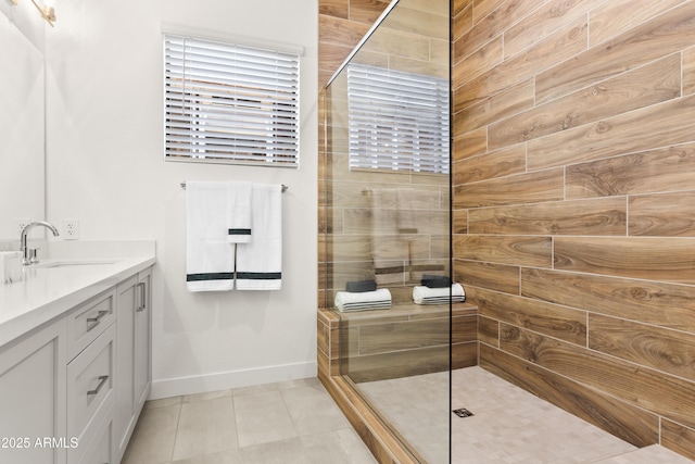 bathroom with vanity, a tile shower, and tile patterned floors