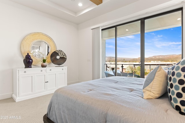 bedroom with a mountain view, light colored carpet, and access to exterior