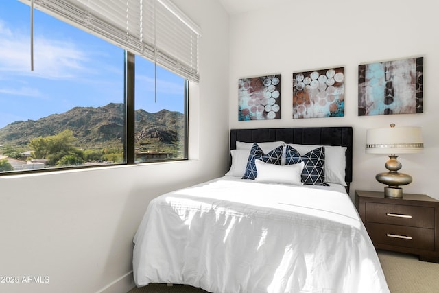 bedroom with light colored carpet and a mountain view