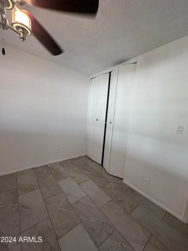 empty room featuring a textured ceiling and ceiling fan