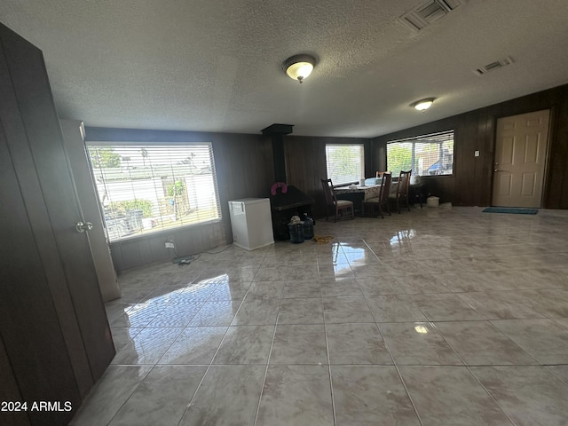 4232 W Citrus Way, Phoenix, AZ 85019 - living room with a wood stove, a textured ceiling, and wooden walls