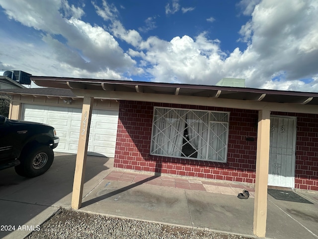 entrance to property with a garage and central AC