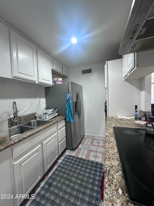 kitchen with stone counters, sink, stainless steel fridge with ice dispenser, exhaust hood, and white cabinetry