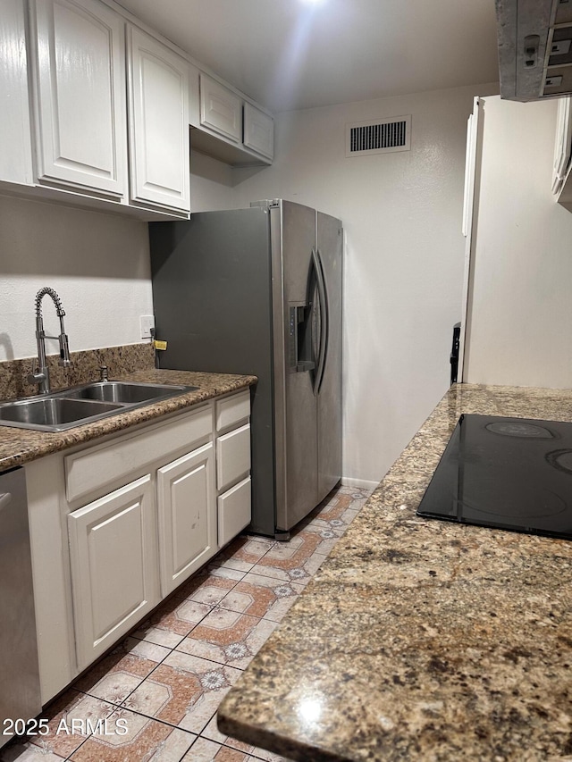 4232 W Citrus Way, Phoenix, AZ 85019 - kitchen featuring a sink, stainless steel fridge, dishwashing machine, black electric stovetop, and white cabinetry