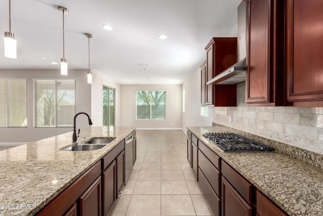 kitchen with pendant lighting, sink, appliances with stainless steel finishes, light stone countertops, and decorative backsplash