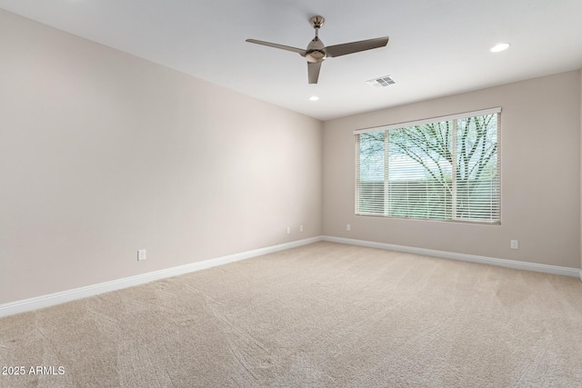 spare room featuring ceiling fan and light colored carpet