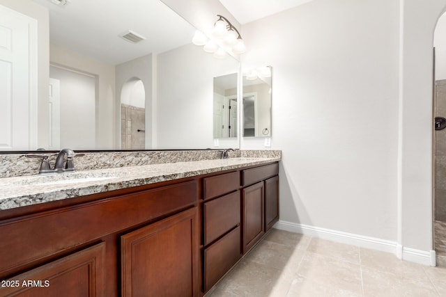 bathroom featuring vanity, tile patterned floors, and walk in shower