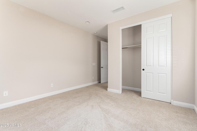 unfurnished bedroom featuring a closet and light carpet