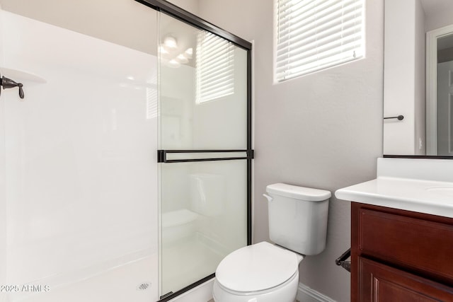 bathroom with vanity, a shower with shower door, and toilet