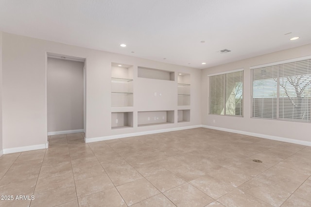 unfurnished living room featuring built in shelves