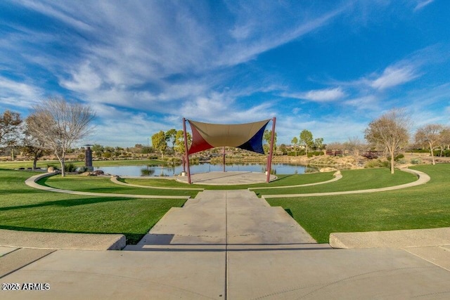 view of home's community with a water view and a yard