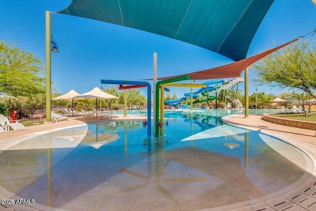 view of swimming pool featuring a water slide and a patio