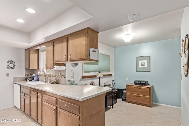 kitchen with light tile patterned floors, a sink, baseboards, light countertops, and backsplash