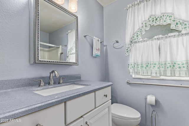 full bathroom with vanity, toilet, and walk in shower