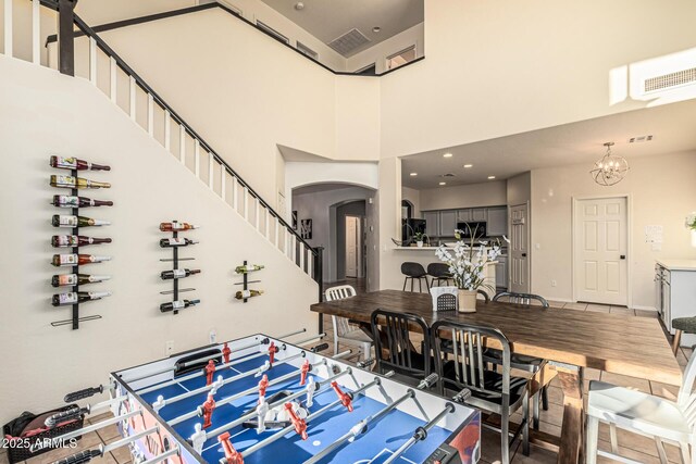 6846 S 26th Pl, Phoenix, AZ 85042 - dining area with arched walkways, a high ceiling, stairs, and a chandelier