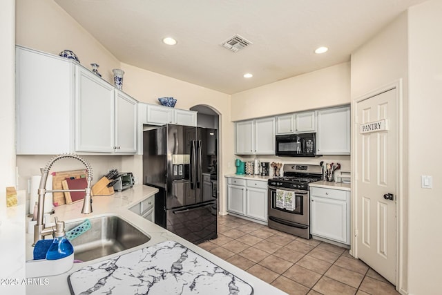 6846 S 26th Pl, Phoenix, AZ 85042 - kitchen featuring black appliances, light countertops, light tile patterned floors, recessed lighting, and arched walkways