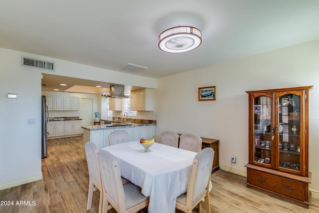 dining space with light hardwood / wood-style flooring and sink