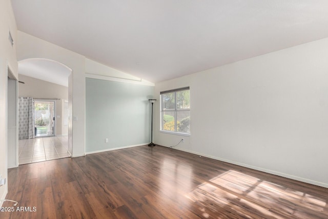 2615 N 123rd Dr, Avondale, AZ 85392 - unfurnished room featuring lofted ceiling, arched walkways, plenty of natural light, wood finished floors, and baseboards