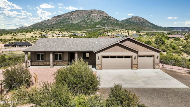 view of front facade featuring a mountain view, covered porch, and a garage