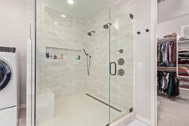 bathroom with washer / dryer and a shower with shower door