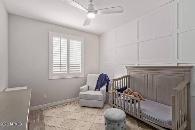 bedroom featuring hardwood / wood-style flooring, ceiling fan, and a crib