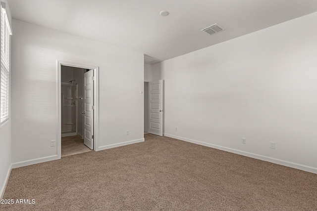 unfurnished bedroom with ensuite bathroom and carpet floors