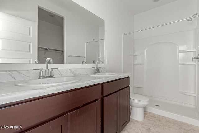 bathroom featuring toilet, vanity, and walk in shower