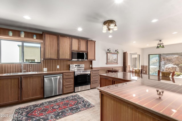 8752 E Range Rider Trl, Mesa, AZ 85207 - kitchen with stainless steel appliances, a sink, plenty of natural light, brown cabinetry, and recessed lighting