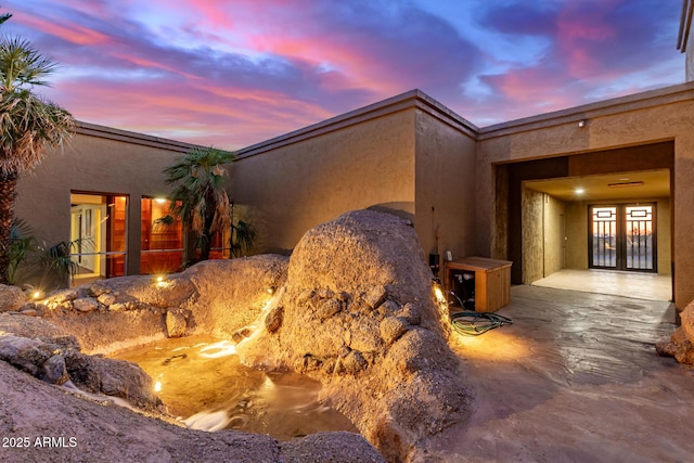 8752 E Range Rider Trl, Mesa, AZ 85207 - property exterior at dusk with french doors and stucco siding