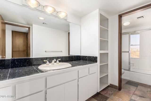 8752 E Range Rider Trl, Mesa, AZ 85207 - full bathroom with vanity, toilet, tub / shower combination, and stone finish floors