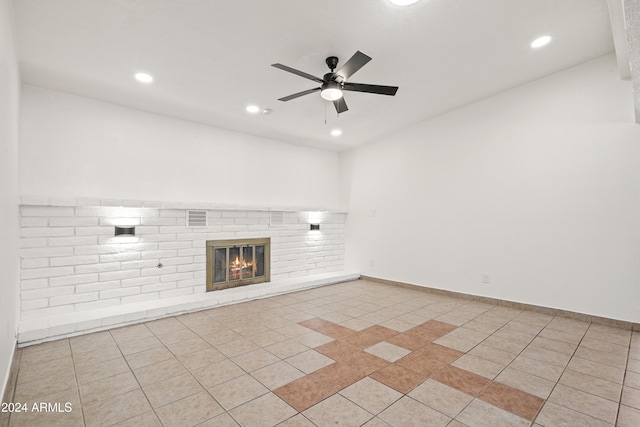 unfurnished living room with a fireplace, light tile patterned floors, and ceiling fan