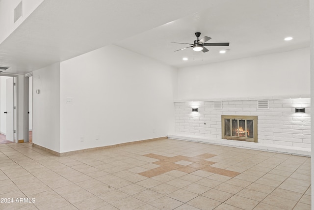 unfurnished living room with a fireplace, ceiling fan, and light tile patterned flooring