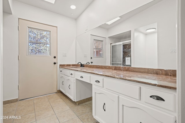 bathroom featuring vanity, a skylight, and tile patterned floors