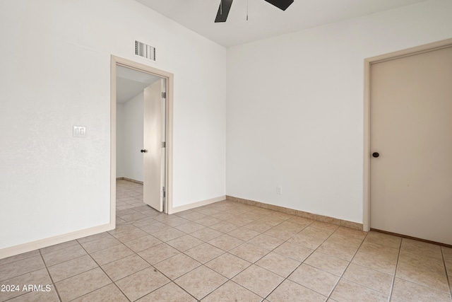 tiled empty room featuring ceiling fan