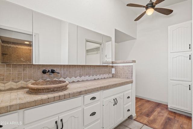 kitchen featuring white cabinets, wood-type flooring, and decorative backsplash